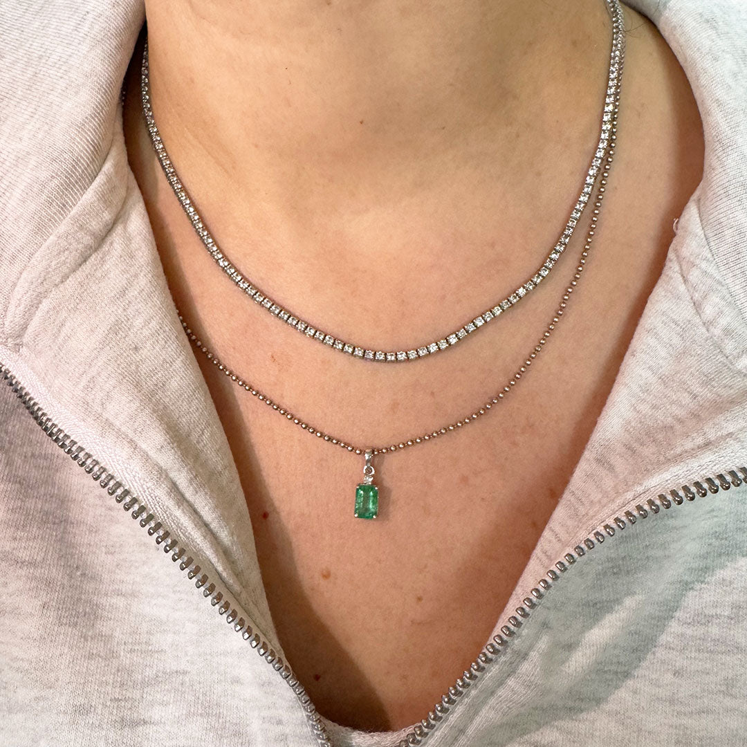 Dije esmeralda con diamante en oro blanco.