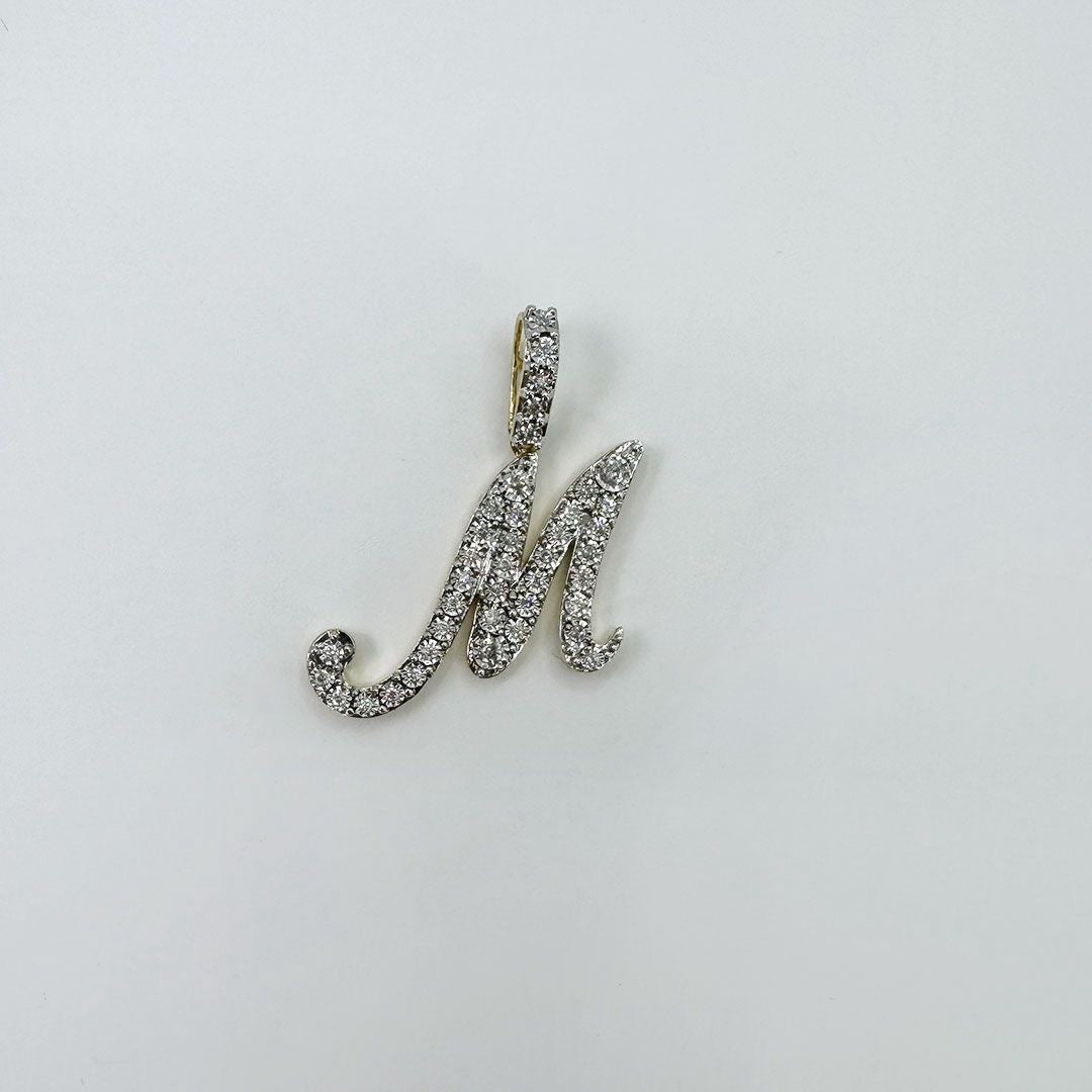 Dije letra M cursiva XL oro y diamantes.