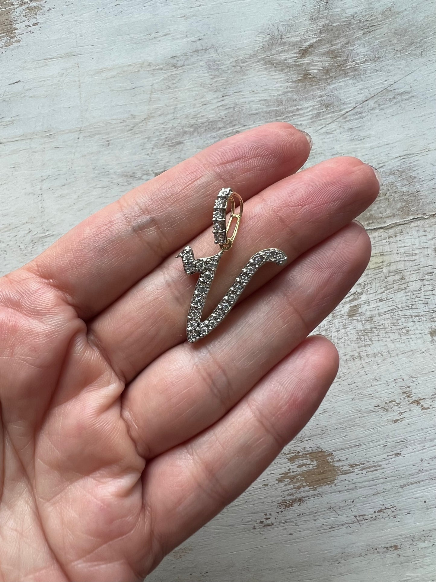 Dije letra "V" XL cursiva oro y diamantes.