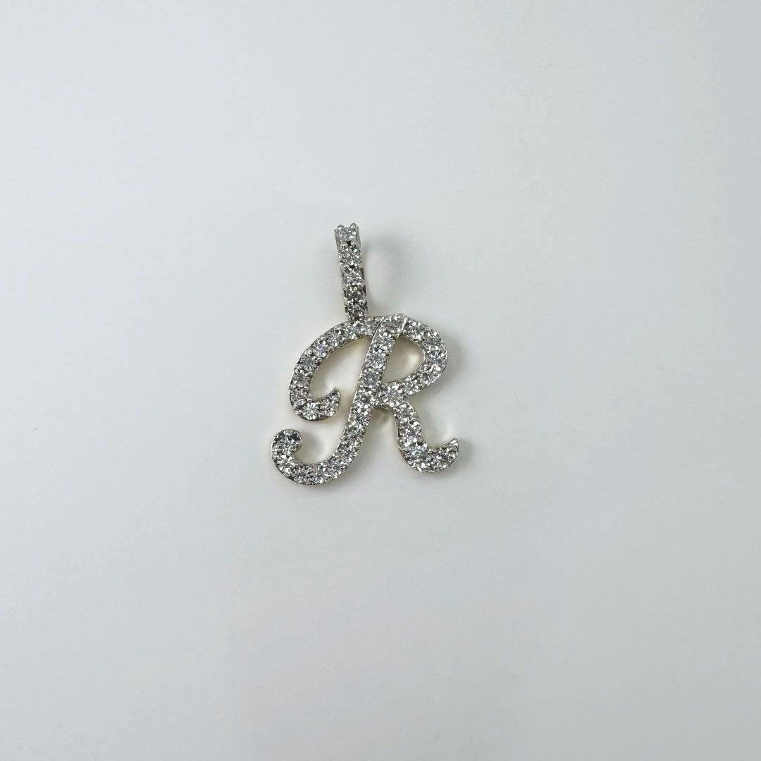 Dije letra "R" cursiva en oro y diamantes.