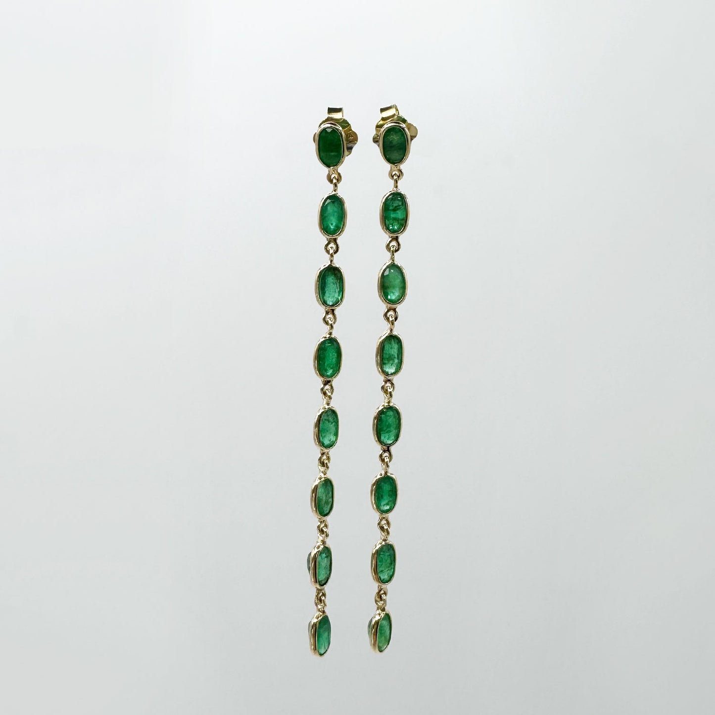 Aretes tira esmeraldas y oro.