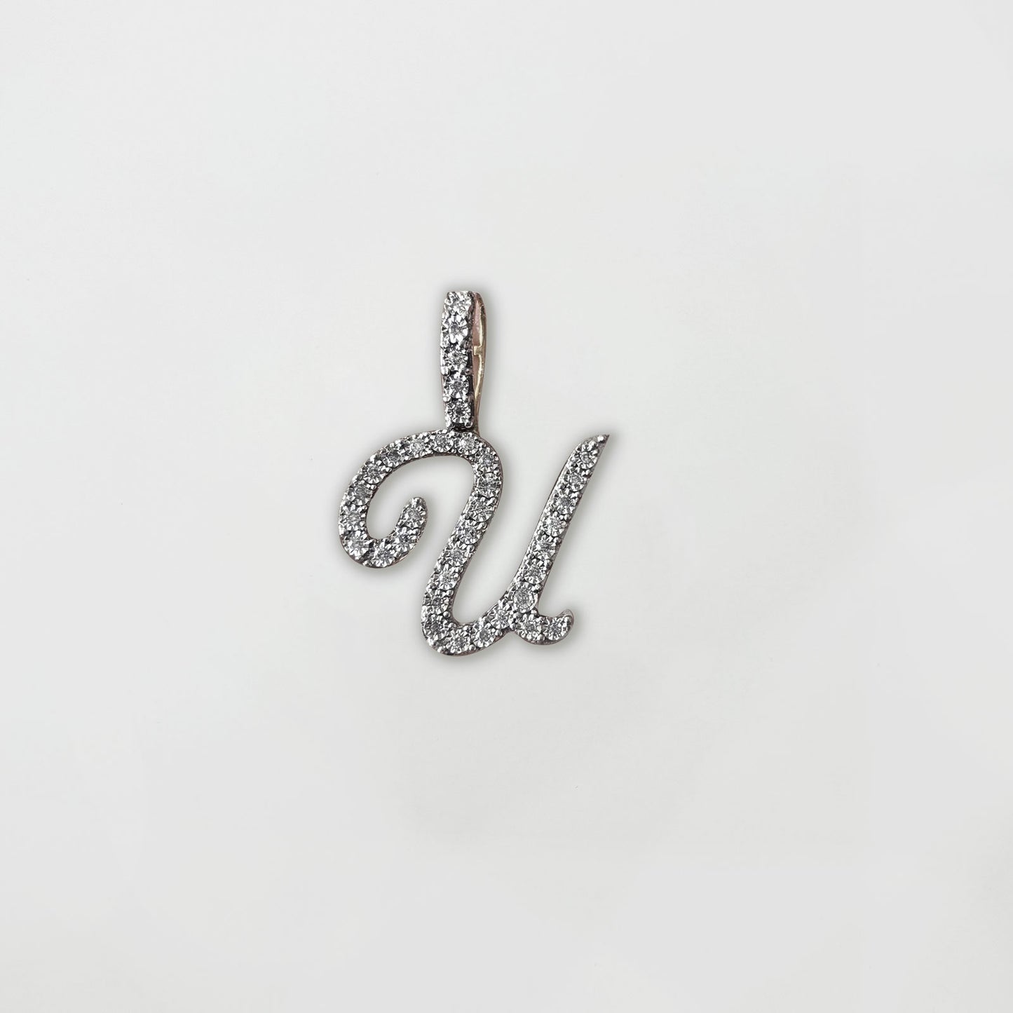 Dije letra "U" XL cursiva en oro y diamantes.