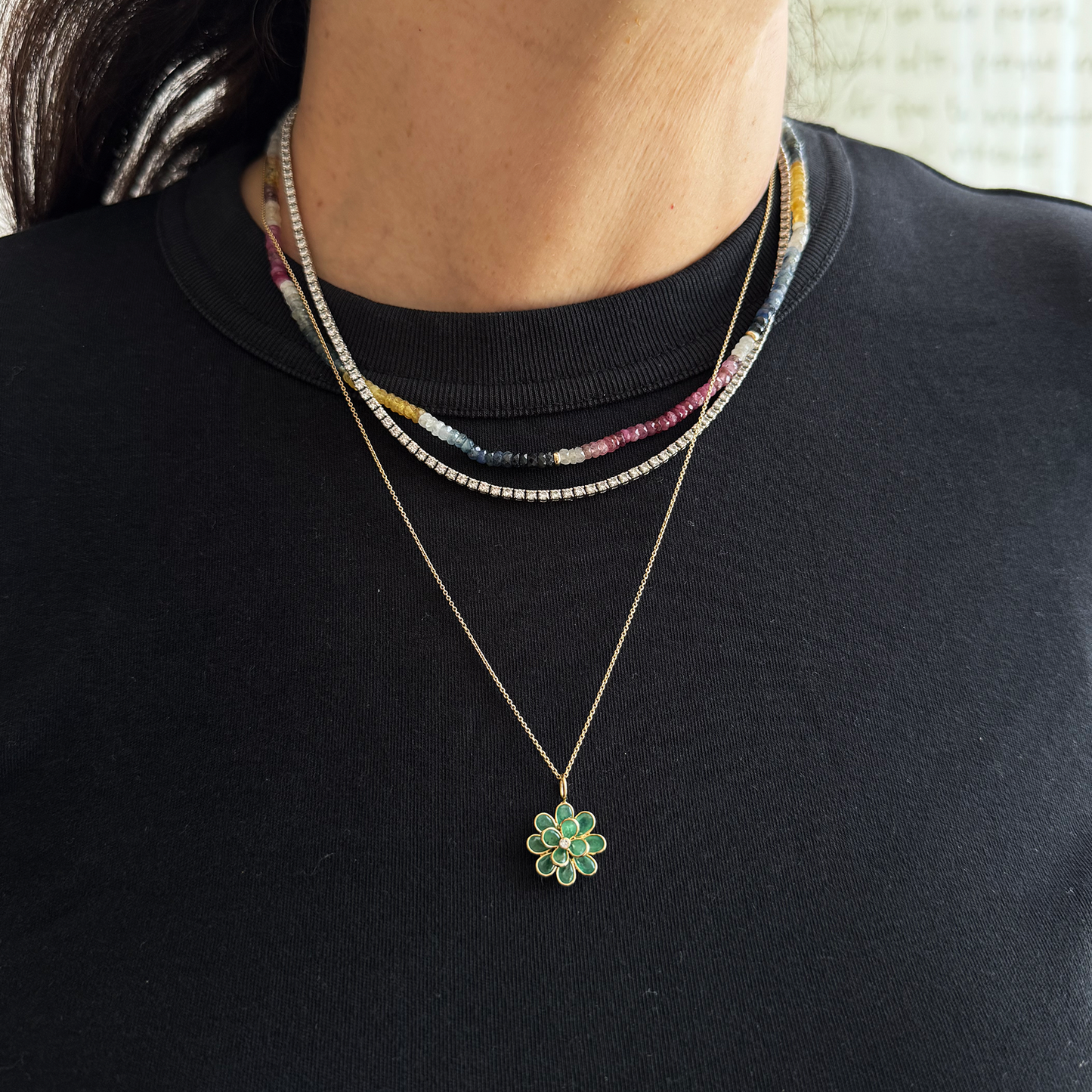 Dije flor esmeralda.