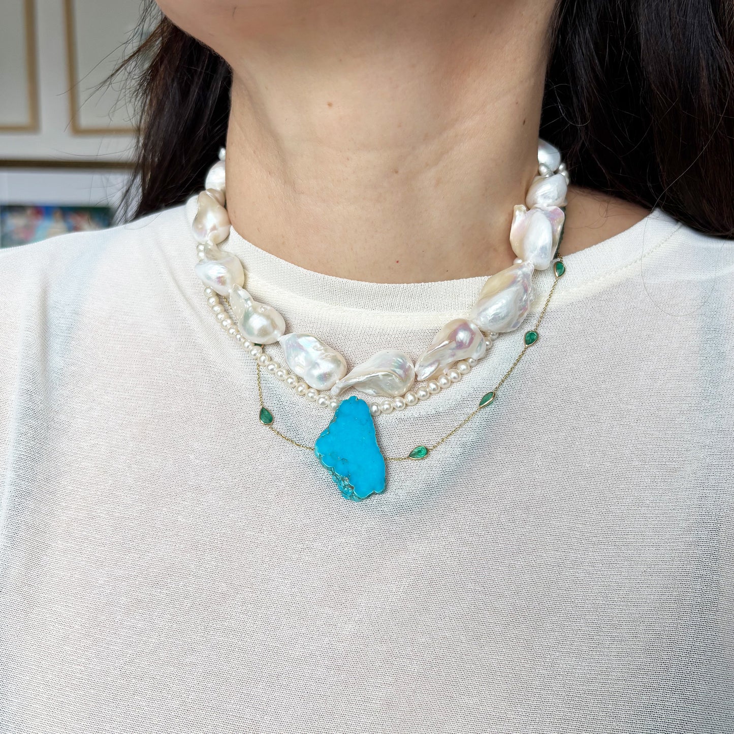 Collar de perlas con una turquesa.