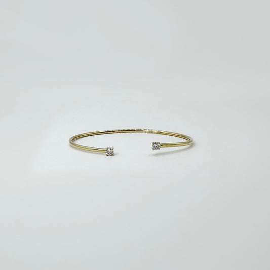 Pulsera rígida con dos diamantes naturales en oro amarillo.