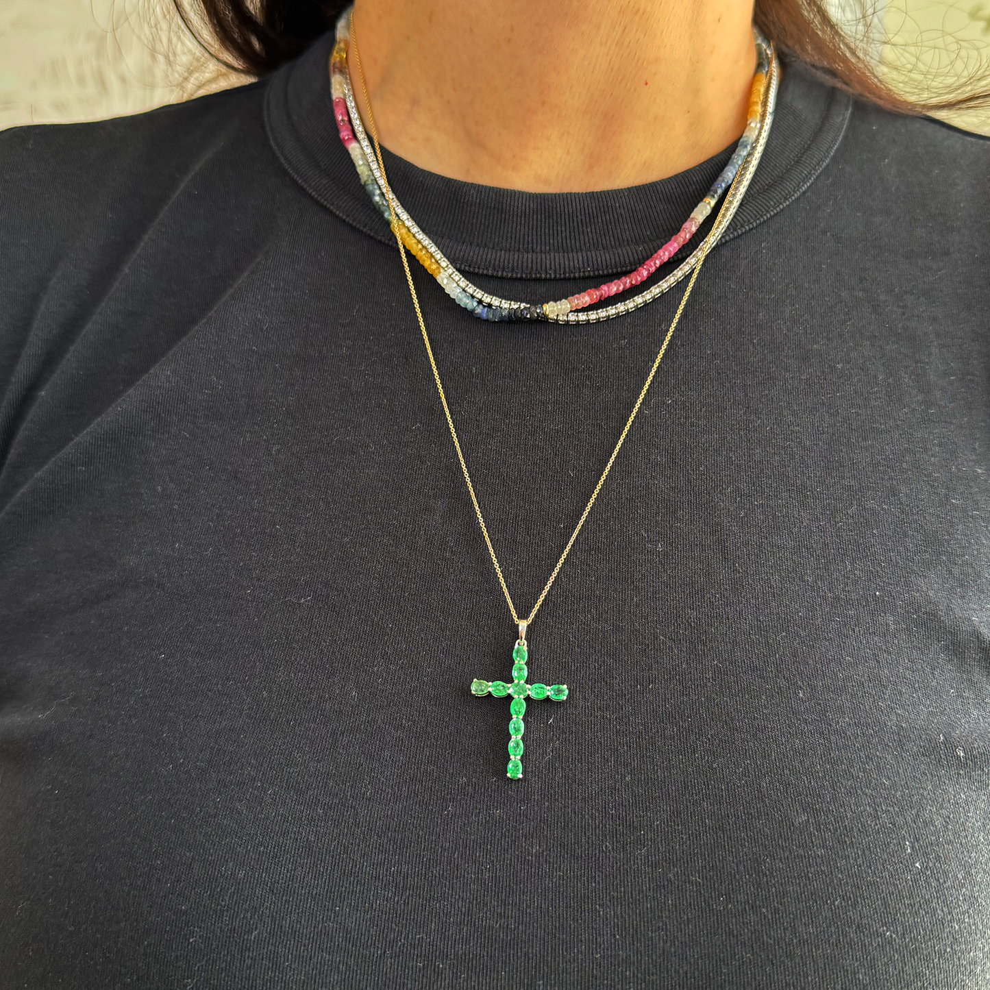 Dije cruz esmeralda y oro blanco.