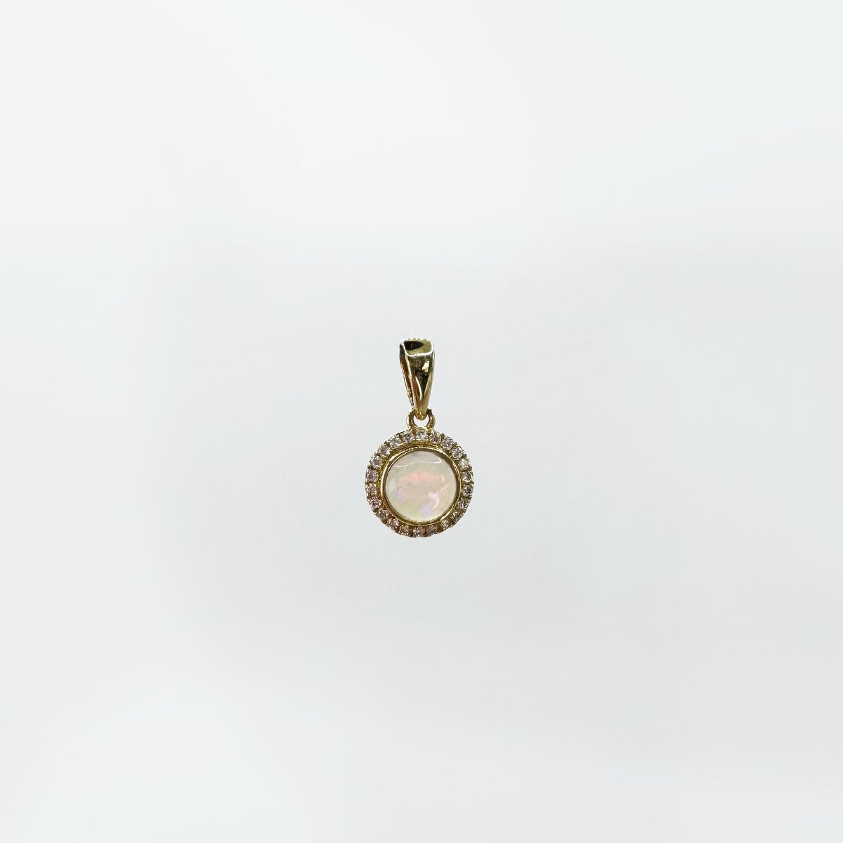 Dije ópalo circular con halo diamantes.