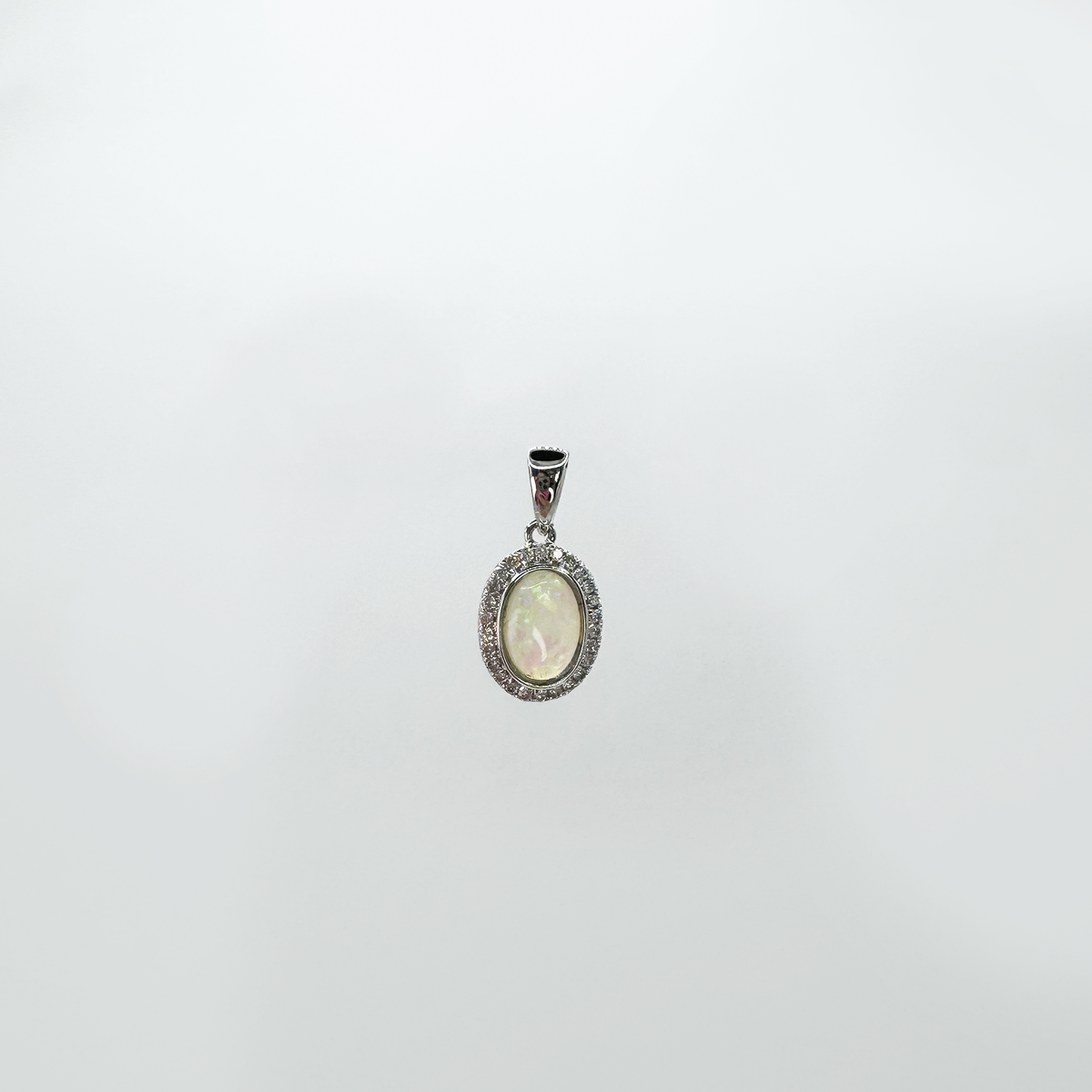 Dije ópalo oval con halo diamantes.