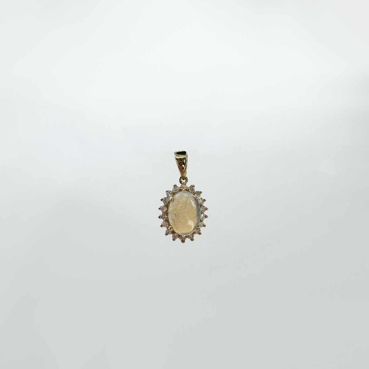 Dije ópalo oval con halo diamantes estrella.