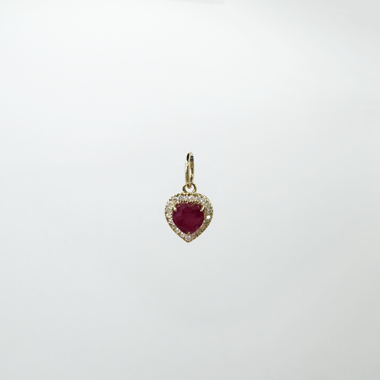 Dije corazón rubí con halo diamantes y oro.