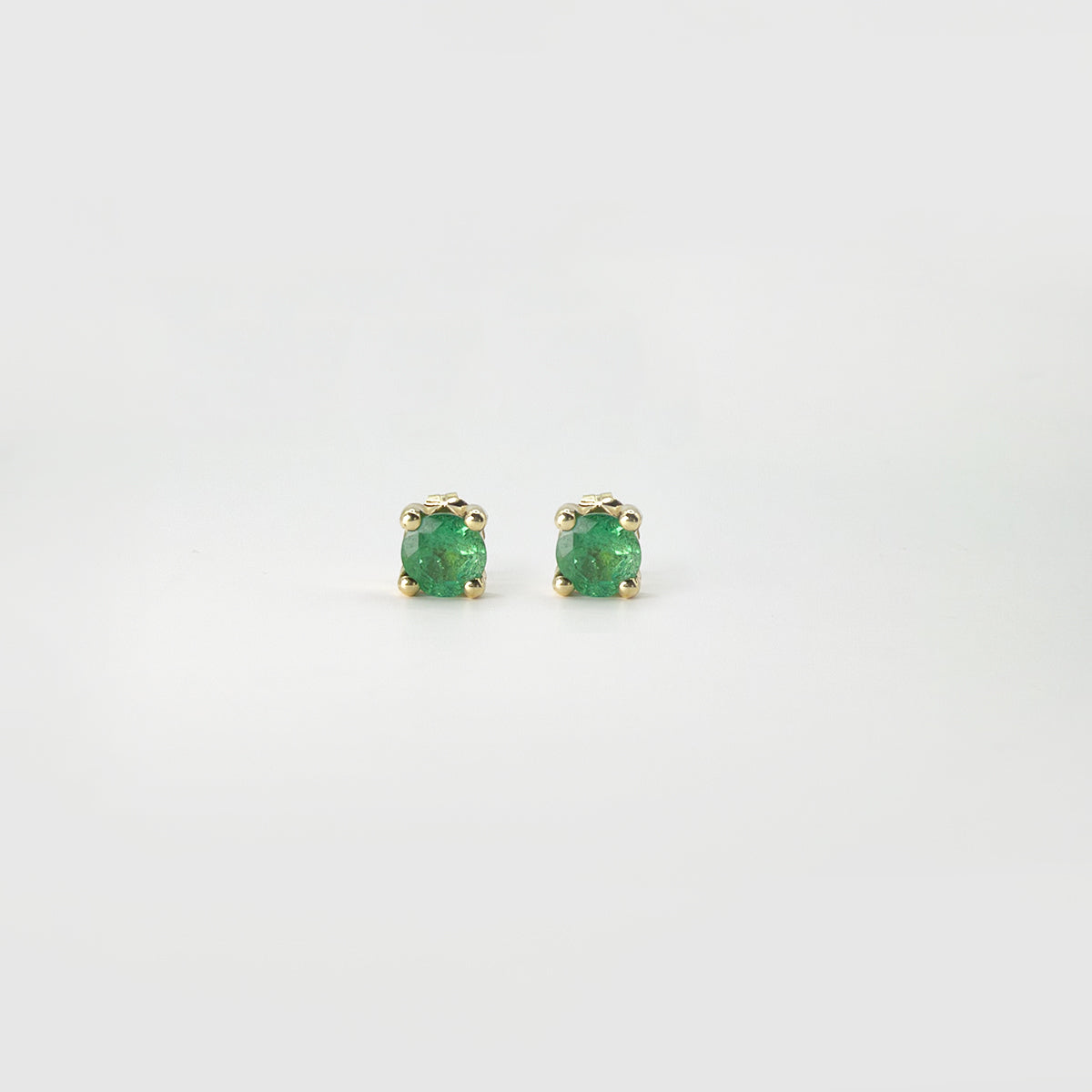 Aretes clásicos esmeraldas redondos oro.