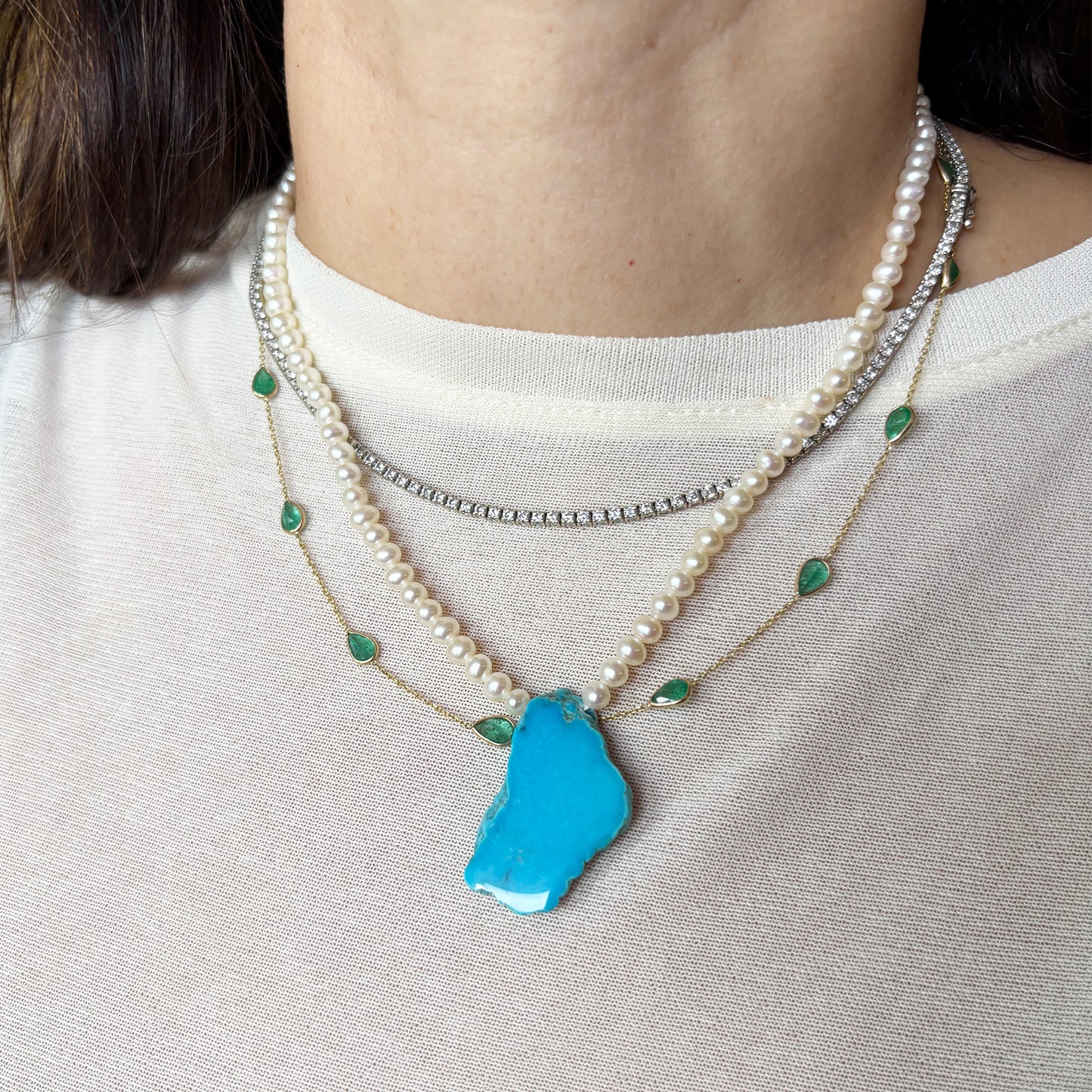 Collar de perlas con una turquesa.