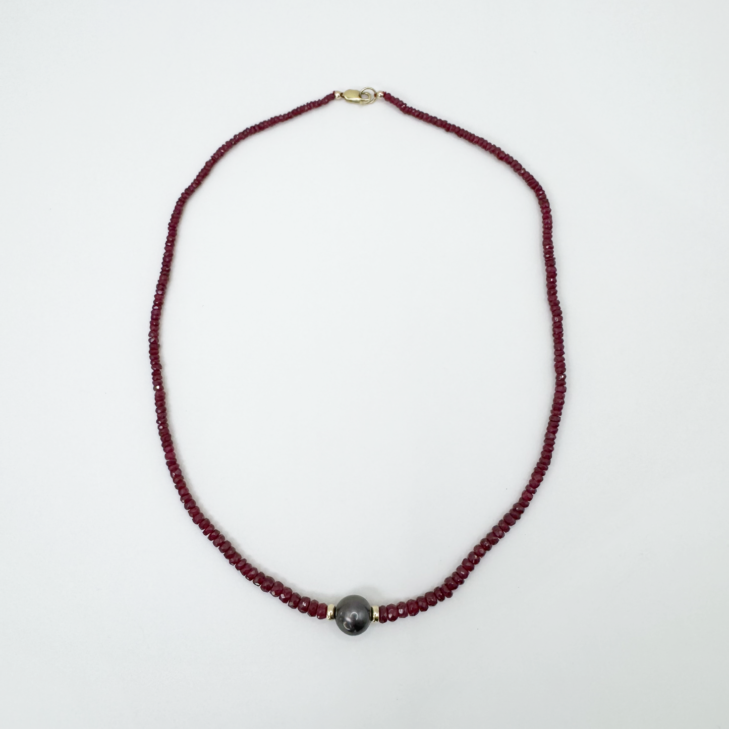 Collar de rubíes con oro y perla negra.