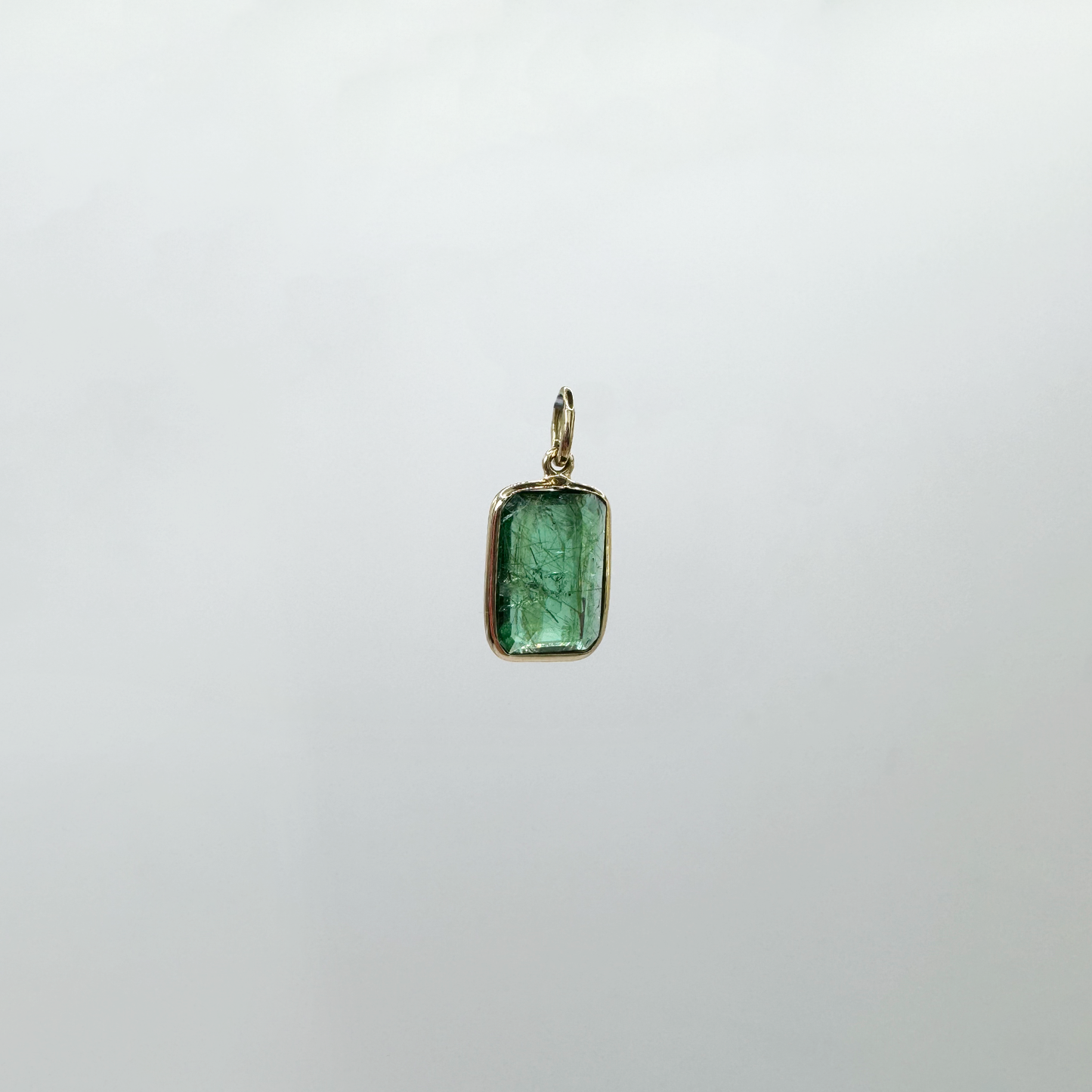 Dije esmeralda con jardín y oro.