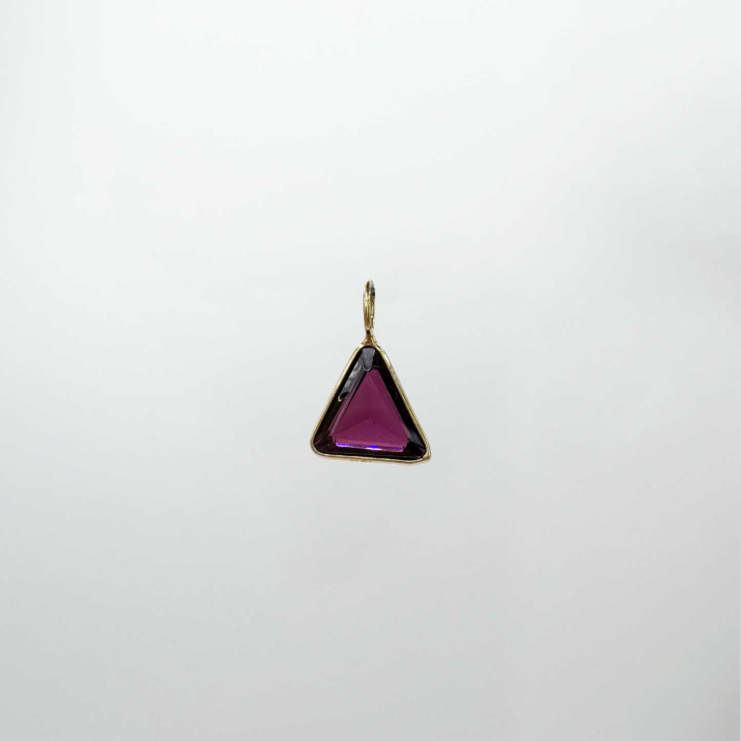 Dije triángulo granate y oro.