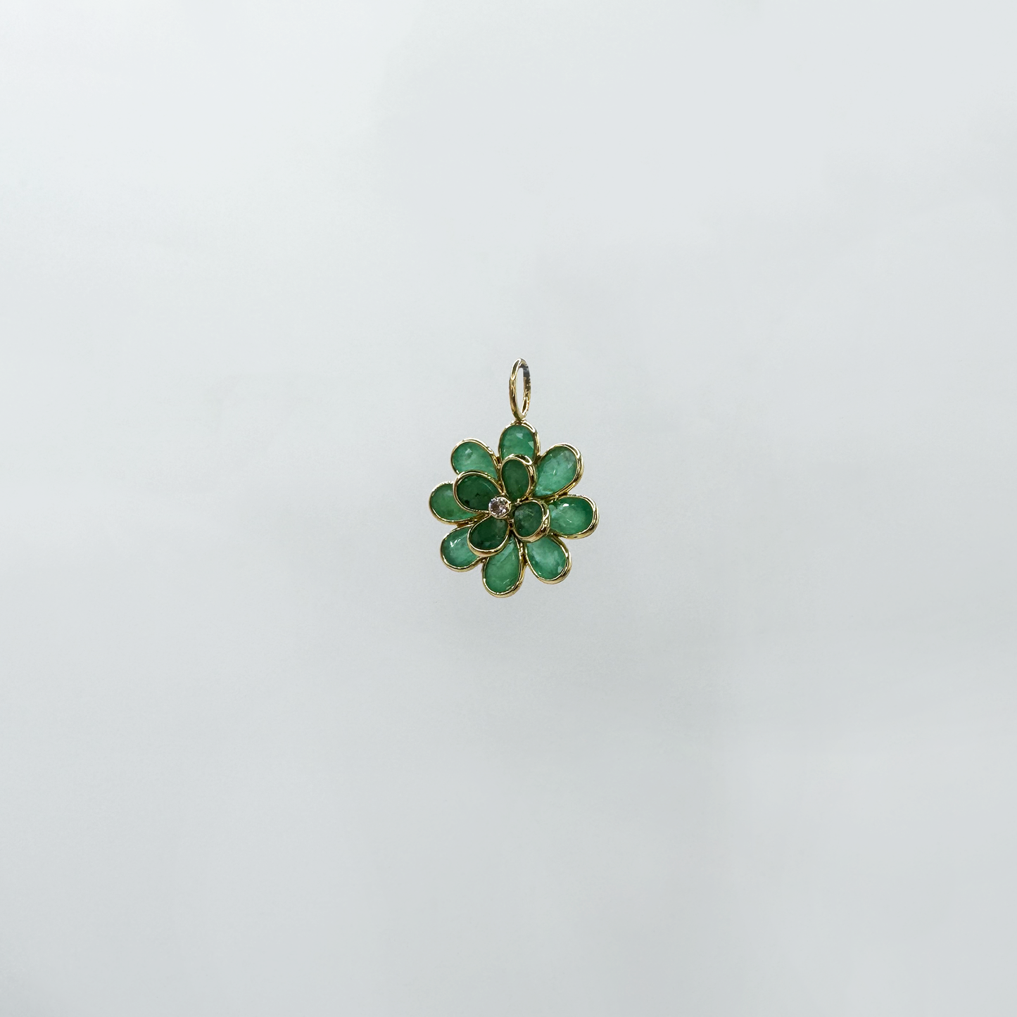 Dije flor esmeralda.