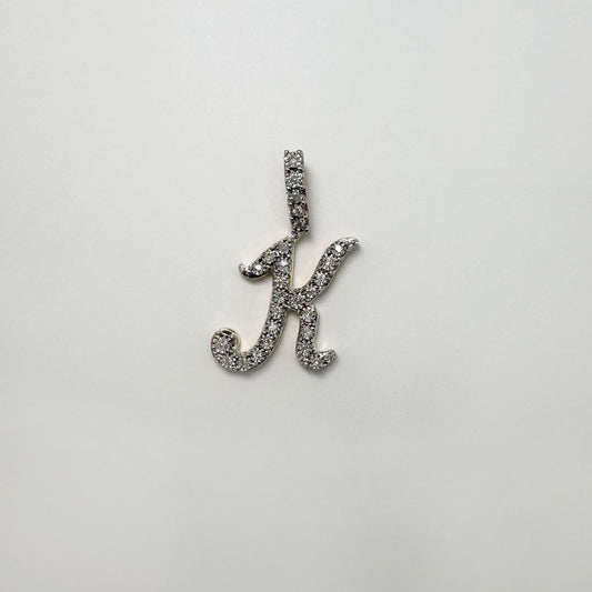 Dije letra "K" cursiva en oro y diamantes.
